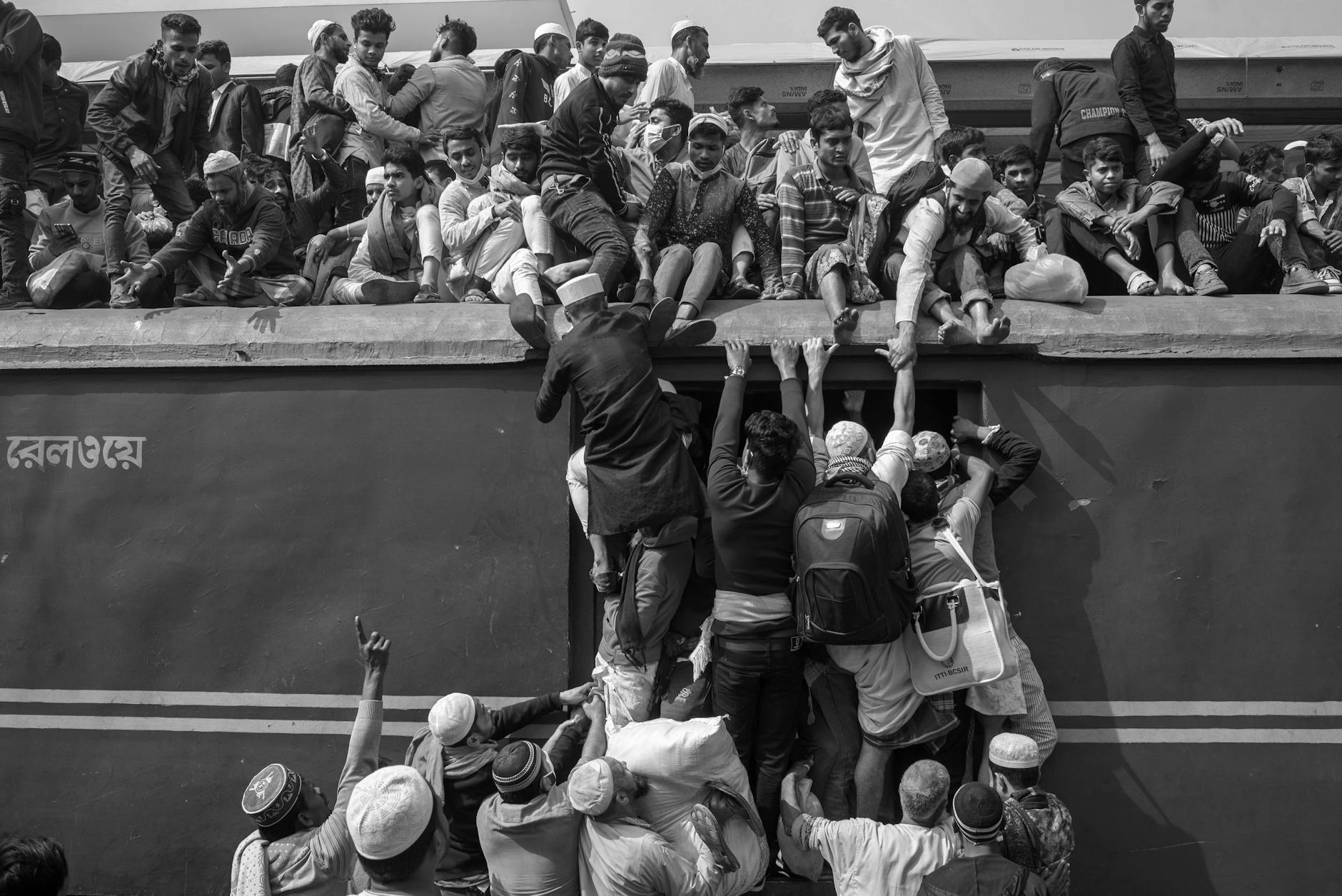 passengers climbing on train car rooftop